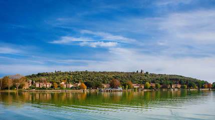 Fototapeta na wymiar Isola Maggiore (Greater Island) of Lake Trasimeno in Umbria, with small village and the medieval St Micheal Archangel church at the top
