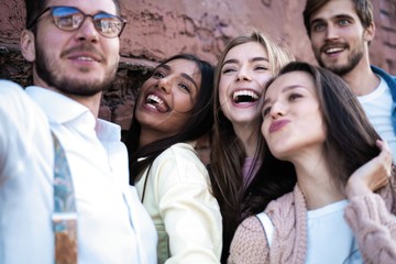 holidays, vacation and happiness concept - group of friends taking selfie with smartphone