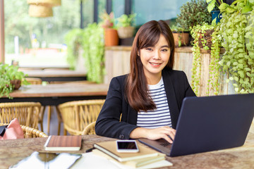 Fototapeta na wymiar Young attractive business woman in her casual suit working on her computer at outdoor patio of her office, working mobile or young entrepreneur concept