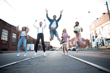 Group of young people having fun together outdoors in urban background.