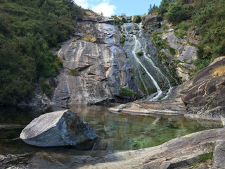 Natural swimming pools and waterfall in summer. "As pozas do rio Pedras" in La Coruna, Spain