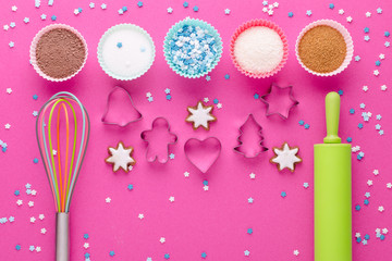 ingredients for baking and kitchen tools with cookie cutter on pink background, flat lay