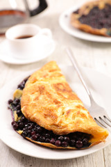 fried egg omelet with blueberries and coffee cup