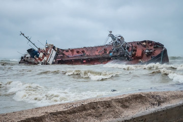 Oil tanker washed ashore having studded the city beach of Odessa, Ukraine, with tons of oil. The Dolphin city beach, Odessa, Ukraine. November 22, 2019.