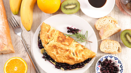 fried egg omelet with blueberries, coffee cup and fruits