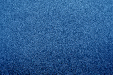 Plastic glittering texture with blur effect in navy blue color.
