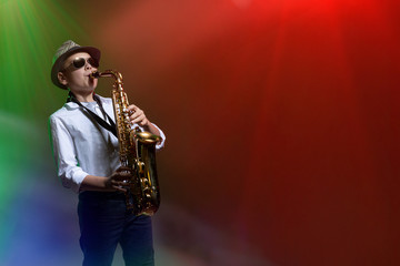 Fototapeta na wymiar Young boy playing his saxophone