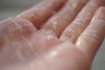 Fototapeta premium Wet hand with soap foam, macro photo.