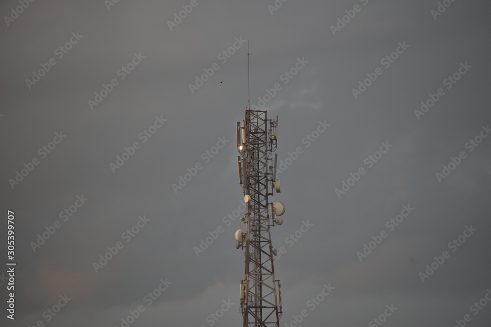 Wall mural cell phone antenna tower, signal tower with clouds background, telecommunication tower antenna