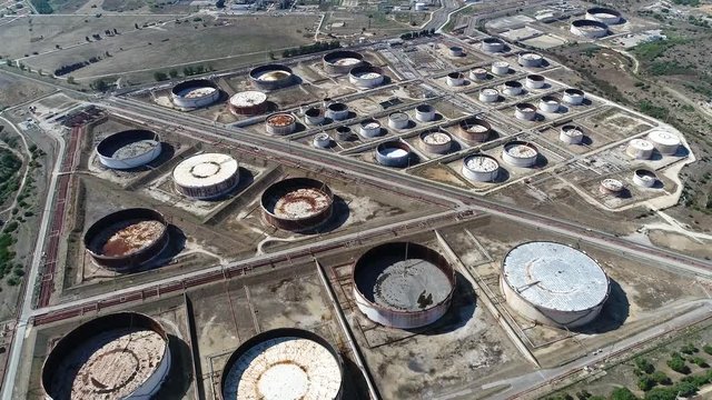 Aerial of empty oil depots sometimes called tank farm installation or terminal is an industrial facility for the storage of petrochemical products indicating low reserves 4k high resolution quality