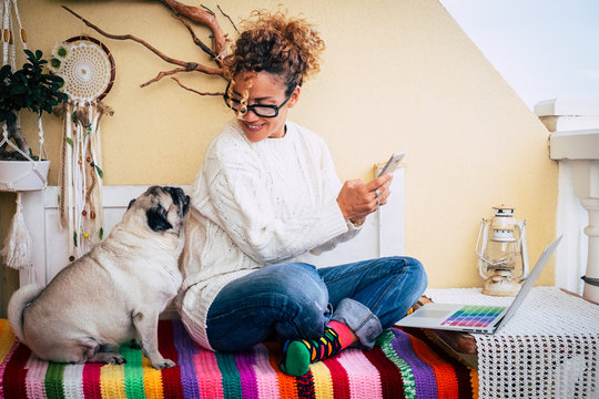 Happy Couple People And Animals With Cheerful Beautiful Caucasian Woman And Her Lovely Pug Dog Sit Down At Home While Work With Technology Devices Like Phone And Laptop