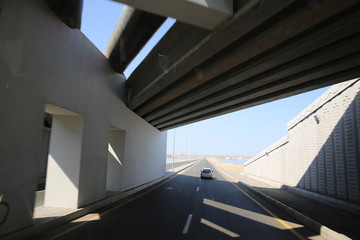 Concrete narrow underground tunnel for cars. Under the bridge is a pedestrian crossing.A small tunnel under the bridge on the road . road tunnel under bridge at day .