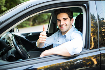 Young man in a car with thumbs up