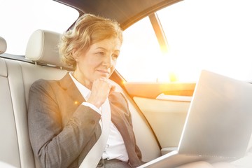 Confident executive using laptop in car