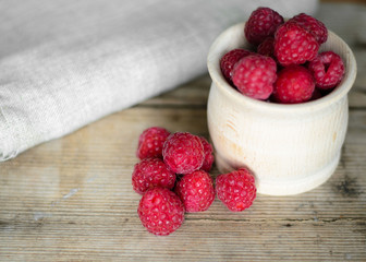 Fresh raspberry in a wooden plate with wooden spoon. Rustic style. Close up. Zero waste concept