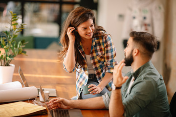 Colleagues in office. Businesswoman and businessman discussing work in office. Two friends in working together.  