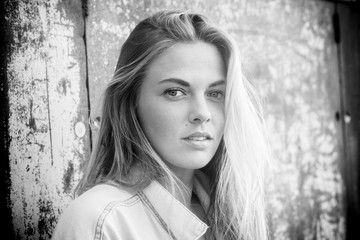 close up of face of a beautiful and attractive woman - blonde teenager on the street - portrait of model - black and white photo