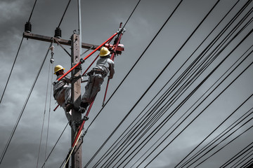 The lineman are replacing damaged insulator insulators by using insulated wire-tong sets, tie stick...