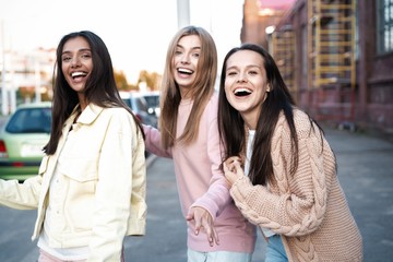 Outdoor shot of three young women having fun on city street