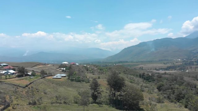 Settlement in remote rainforest valley with church by drone