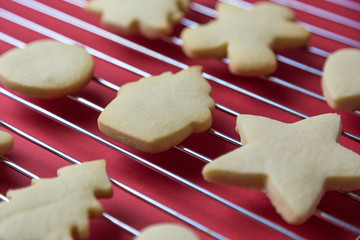 Close up of christmas cookies on oven grate against red background minimal creative holiday and food concept.