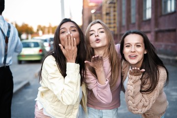 Outdoor shot of three young women having fun on city street