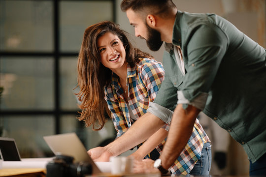 Colleagues in office. Businesswoman and businessman discussing work in office. Two friends in working together.  