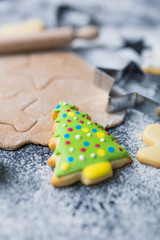 Making Christmas cookies concept made of sugar, cutters, dough, rolling pin and biscuit with colorful icing on table.