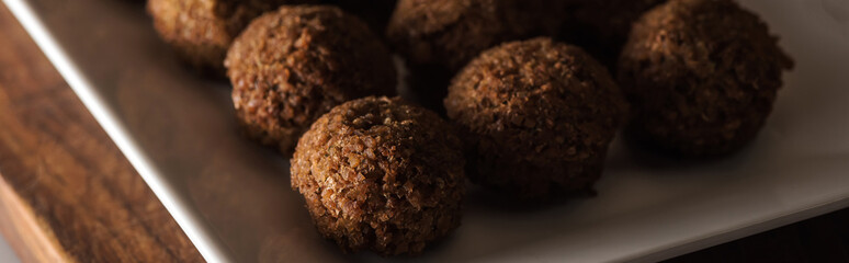 close up view of falafel balls on white plate, panoramic shot