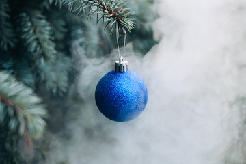 Christmas toy on the branches of a New Year tree. Christmas tree decorated with a festive ball