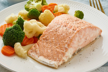 Steam salmon and vegetables, Paleo, keto, fodmap, dash diet. Mediterranean diet with steamed vegetables and fish. Healthy concept, gluten free, lectine free, white plate on gray table, macro