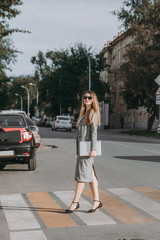 girl with a laptop walking around the city