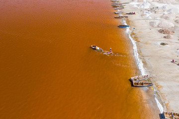 Aerial view of the small boats for salt collecting at pink Lake Retba or Lac Rose in Senegal. Photo made by drone from above. Africa Natural Landscape.