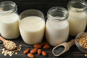 Glasses with diferent types milk on wooden background, space for text. Closeup