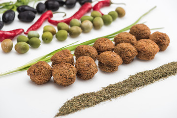 close up view of olives, chili pepper, green onion, herb and falafel on white background