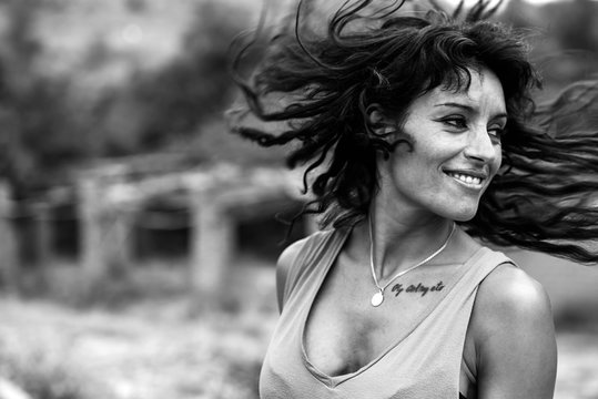 Mujer joven agita larga melena morena