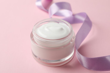 Jar of winter cream for skin on pink background, space for text. Closeup