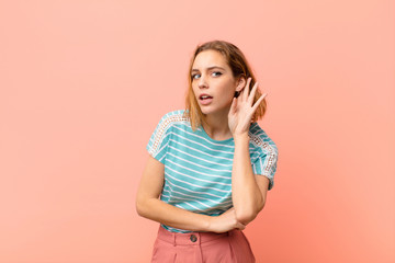 young blonde woman looking serious and curious, listening, trying to hear a secret conversation or...