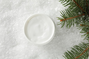 Jar of winter cream for skin, christmas tree on snowy background, space for text. Top view