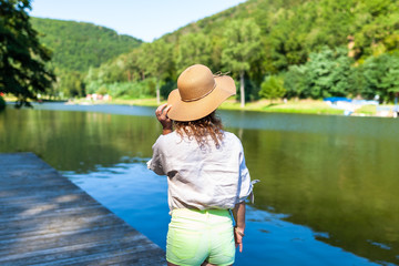 Beautiful happy woman relaxing on the beach next to a lake on a beautiful summer day