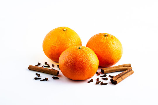 Fresh delicious juicy orange on isolated white background with cinnamon sticks and cloves