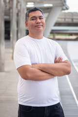 Obraz premium confident old senior man portrait; strong happy healthy asian senior man in city environment; senior old man model for senior citizen, pensioner, retired man concept usage