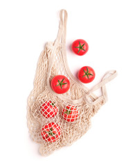 Clean and eco tomatoes in reusable net bag on white