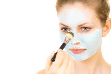 Girl apply green mud mask to face