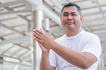 Fototapeta premium confident old senior man clapping his hand; strong happy healthy asian senior man in city environment; senior old man model for senior citizen, pensioner, retired man concept usage