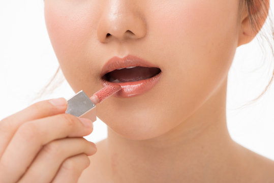 Young beautiful woman professional beauty vlogger or blogger applying lipstick cream to her mouth, doing a make up tutorial