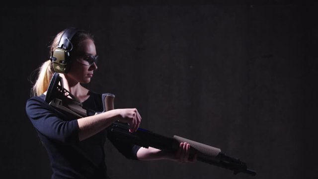 Woman loading shotgun with ammo, person reloading her weapon in shooting range and aiming down sight