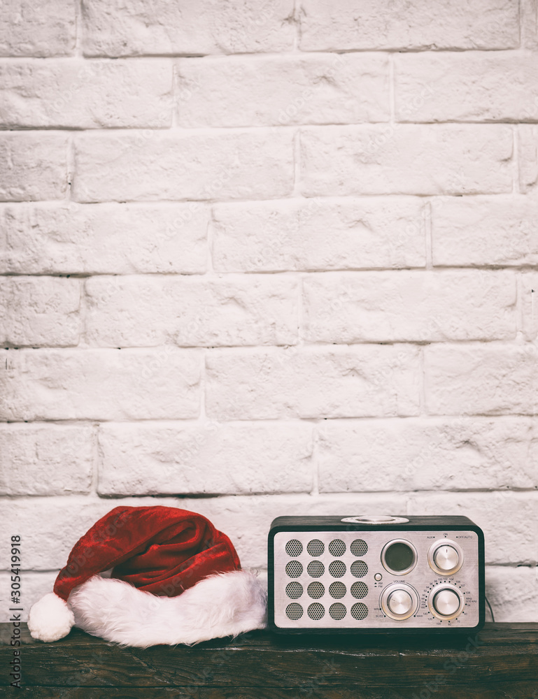 Wall mural radio receiver with santa hat. holidays congratulation in mass media concept