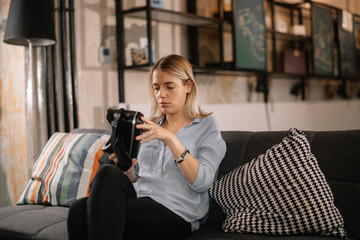 Young woman using vr. Beautiful woman using virtual reality on sofa. . 