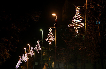 Street New Year and Christmas decorations, string rice lights bulbs. Decorative flashing lights, ornaments shaped of tree and star on top to christmas celebration, holiday scene. Christmas concept.
